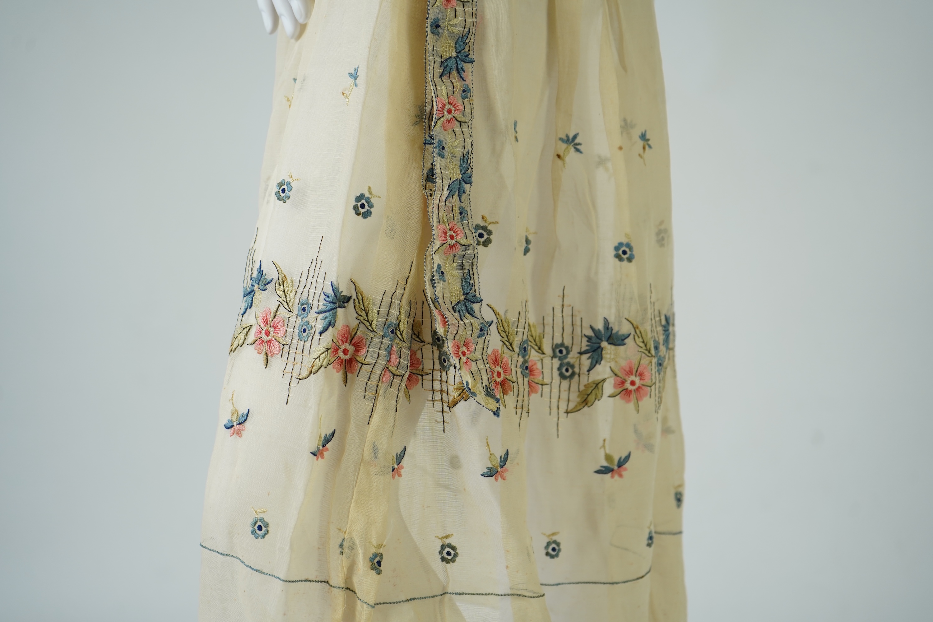 An unusual 1920's fine cream lawn summer dress with hand embroidered blue, pink, flowers, tie and picot edging., 116cm long. Condition - some small rust stains and one small tear at the back right shoulder.
